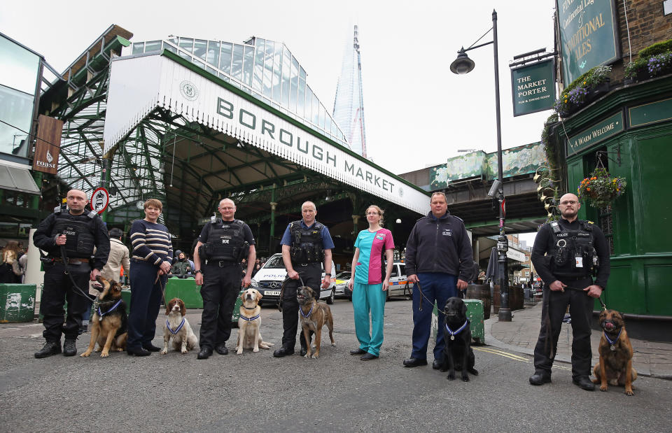 (Left to right) PD Marci with handler PC Neil Billany, PD Kai with handler PC Jean Pearce, PD Bruno with handler Rob Smith, PD Delta with handler PC Mark Snoxhall, PDSA vet Rosamund Ford, PD Dave with handler PC Andy Salter and PD Jax with handler PC Craig Howarth at Borough market in London where the dogs were honoured with the PDSA Order of Merit for helping emergency services during the 2017 London terror attacks at Westminster Bridge, London Bridge and Borough Market.