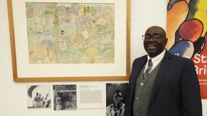 Gift Livingstone Sango, 65, stands next to a painting by his father depicting Jesus as a Black man at the National Gallery of Zimbabwe last month, part of a historic exhibit, “The Stars are Bright,” now showing in Zimbabwe for the first time since the collection left the country more than 70 years ago. A photograph of Sango’s father, Livingstone, as a young boy hangs next to the painting. (Photo: Tsvangirayi Mukwazhi/AP)