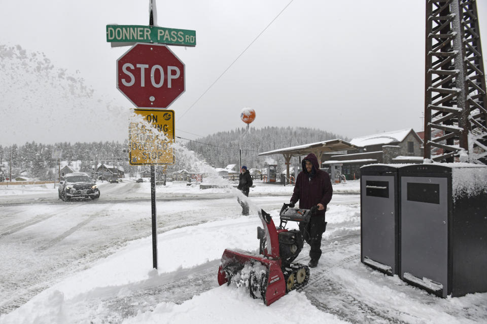Juan Manuel plows the snow off the sidewalk in front of The Bar of American where he is employed on Friday, March 1, 2024, in downtown Truckee, Calif. The most powerful Pacific storm of the season is forecast to bring up to 10 feet of snow into the Sierra Nevada by the weekend (AP Photo/Andy Barron)