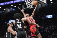Toronto Raptors guard Immanuel Quickley (5) goes to the basket past Brooklyn Nets guard Cam Thomas (24) and center Nic Claxton (33) during the second half of an NBA basketball game, Wednesday, April 10, 2024, in New York. The Nets won 106-102. (AP Photo/Mary Altaffer)