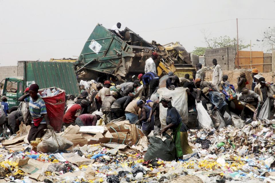 Scavengers pick up trash for recycling at the Olusosun dump site in Nigeria's commercial capital Lagos in this March 23, 2012 file photo. One thing Nigeria's megacity of Lagos, one of the world's largest, generates in abundance is trash. Now it plans to turn that rubbish into electricity which the city desperately lacks. Ola Oresanya, managing director of the Lagos Waste Management Authority (LAWMA) aims to complete the project in around five years, by which time it will have a 25 megawatt (mw) capacity, he said. That is only 1 percent of the 2,000 - 3,000 mw that he estimates Lagosians demand, but it is a start. To match story NIGERIA-RUBBISH/ELECTRICITY/ REUTERS/Akintunde Akinleye/Files (NIGERIA - Tags: ENERGY SOCIETY)