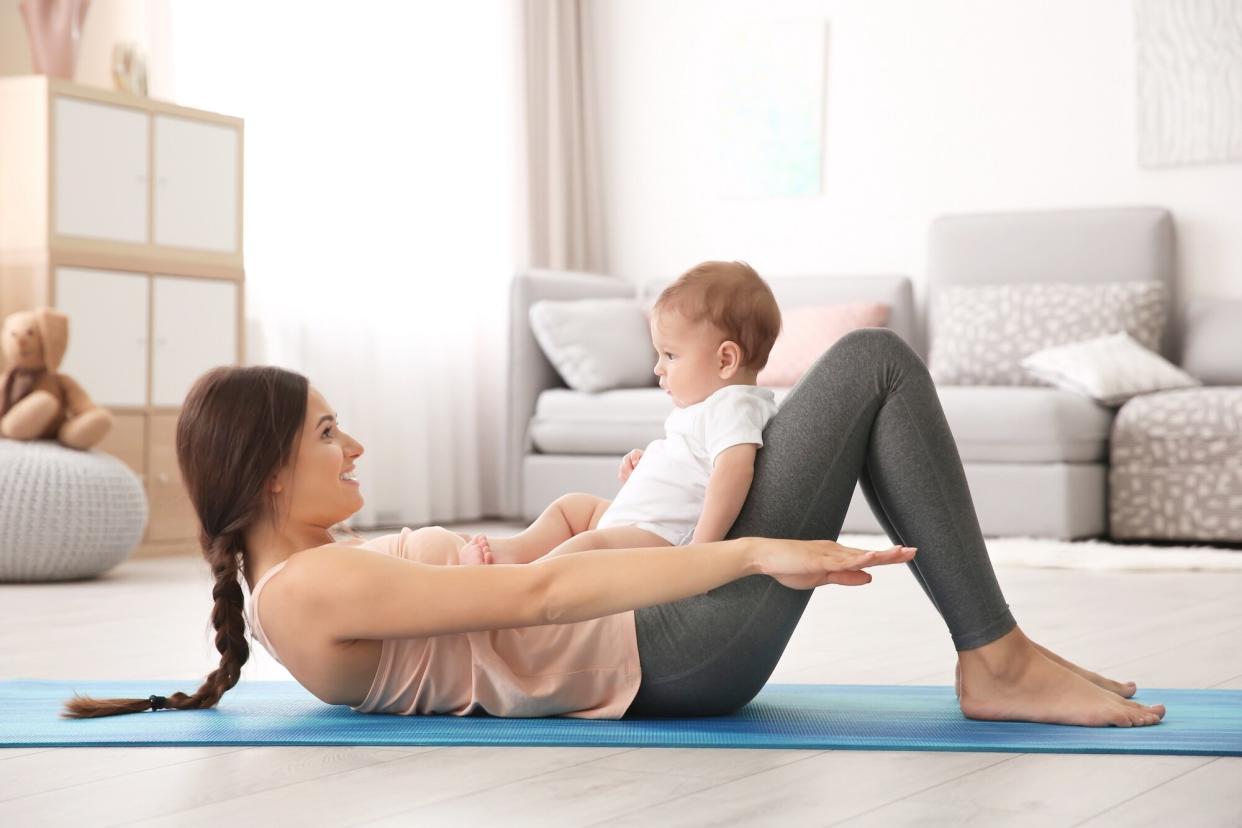 Baby Sitting on Mother Working Out Abs Flutter Yoga