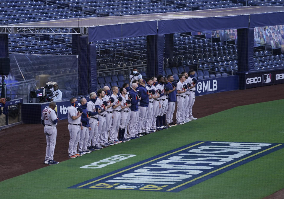 Houston Astros line up for the playing of the national anthem before Game 1 of a baseball American League Championship Series against the Tampa Bay Rays, Sunday, Oct. 11, 2020, in San Diego. (AP Photo/Ashley Landis)