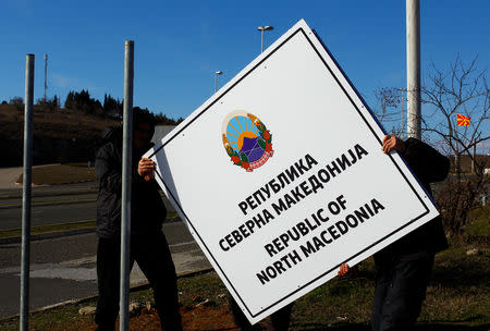 Workers set up a sign with Macedonia's new name at the border between Macedonia and Greece, near Gevgelija, Macedonia February 13, 2019. REUTERS/Ognen Teofilovski