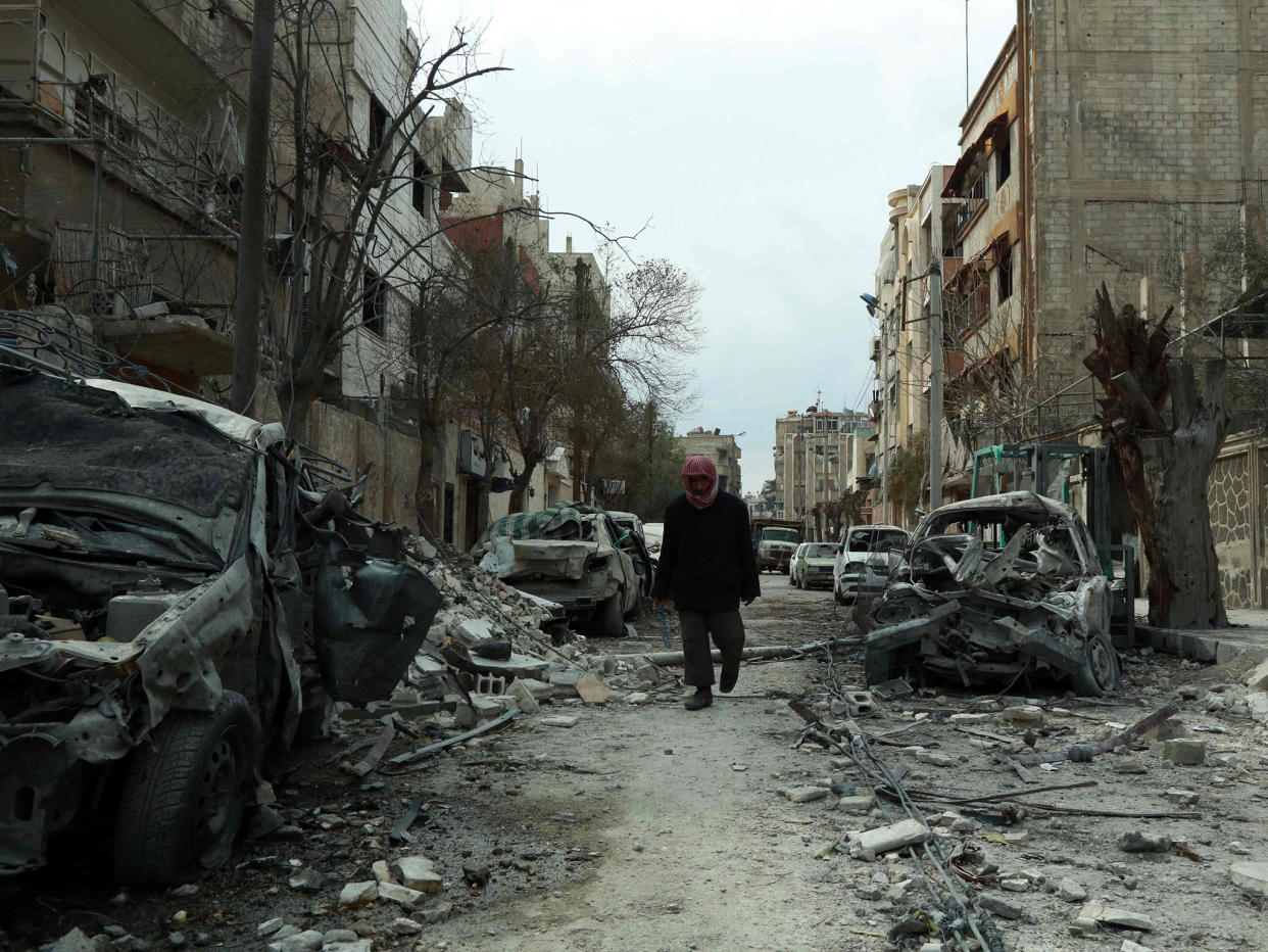 A Syrian man walks next to damaged buildings following regime air strikes in the Syrian rebel-held town of Douma, in the besieged Eastern Ghouta region on the outskirts of the capital Damascus: Getty