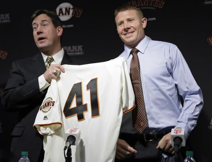 Mark Melancon (right) receives his new jersey from Giants general manager Bobby Evans. (AP)