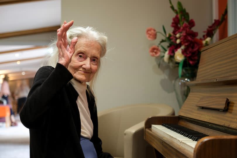 Photo of Victoria sat by a piano