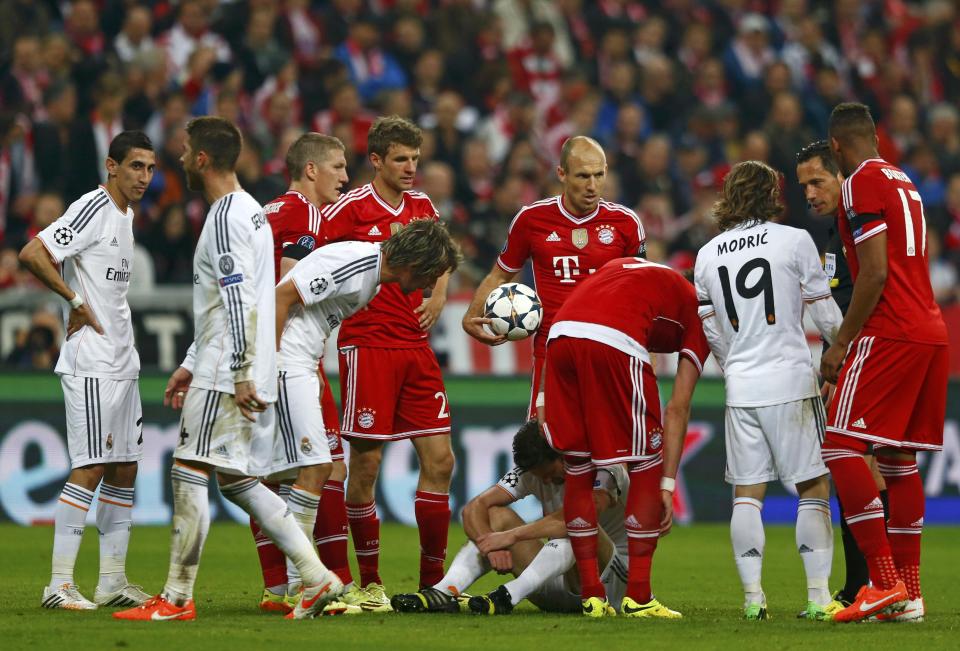 Real Madrid's Alonso sits on the grass after being awarded a yellow card during the Champions League semi-final second leg soccer match against Bayern Munich