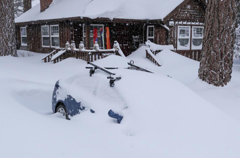 Homes and vehicles are inundated with snow in the latest storm to pound resort areas in the San Bernardino Mountains