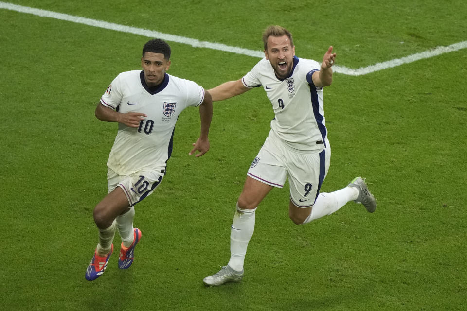 England's Jude Bellingham, left, celebrates with Harry Kane after scoring his side's first goal during a round of sixteen match between England and Slovakia at the Euro 2024 soccer tournament in Gelsenkirchen, Germany, Sunday, June 30, 2024. (AP Photo/Ebrahim Noroozi)