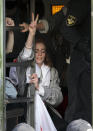 A detained woman gestures from a police bus during an opposition rally to protest the official presidential election results in Minsk, Belarus, Saturday, Sept. 12, 2020. Daily protests calling for the authoritarian president's resignation are now in their second month and opposition determination appears strong despite the detention of protest leaders. (AP Photo)