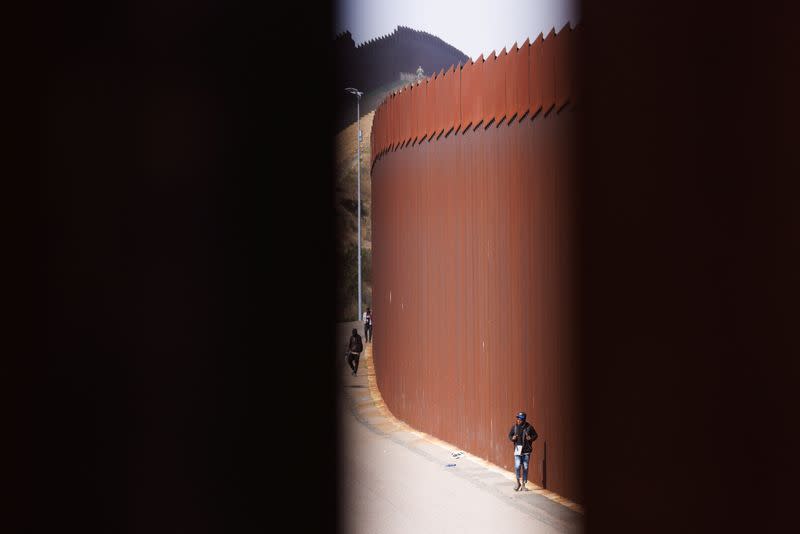 Migrants wait between border fences of U.S. and Mexico in California