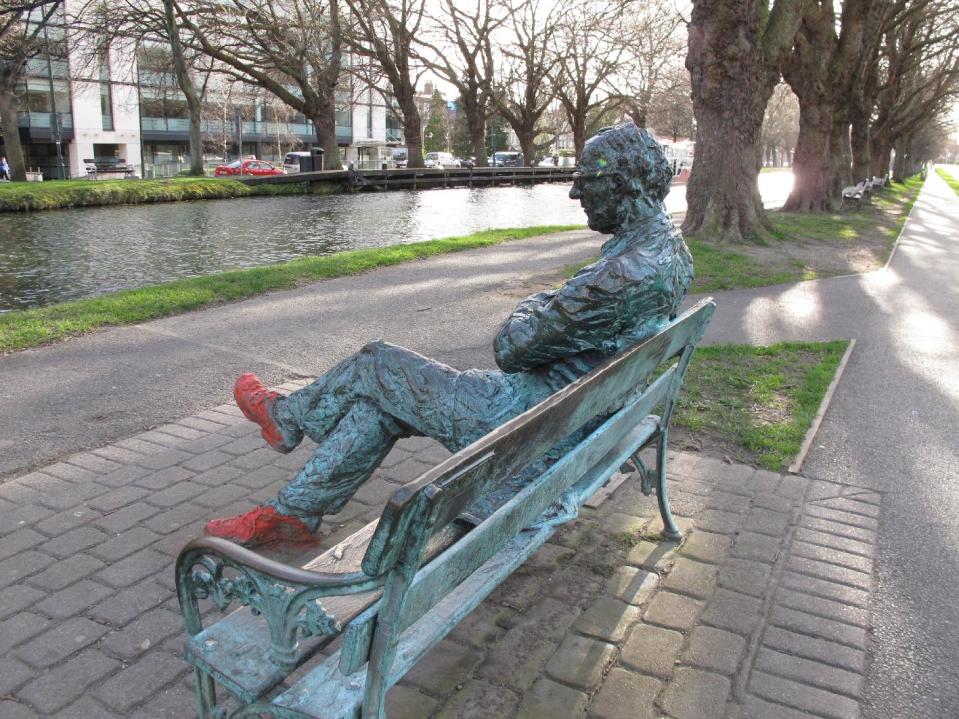 This March 18, 2014 photo shows a bronze depiction of poet Patrick Kavanagh sitting by the Grand Canal in Dublin, Ireland. The statue is one of many commemorating writers throughout the capital city. This was inspired by Kavanagh's poem about the canal: "O commemorate me where there is water, canal water preferably, so stilly greeny at the heart of summer." (AP Photo/Helen O'Neill)