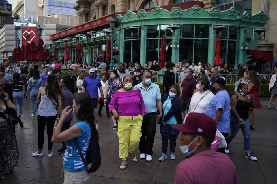 FILE - In this April 24, 2021, file photo, people walk along the Las Vegas Strip in Las Vegas. Masks are back in Las Vegas, where regional health officials pointed Friday, July 16, 2021, to a rising number of coronavirus cases and advised everyone, vaccinated or not, to wear facial coverings in crowded indoor places. (AP Photo/John Locher, File)