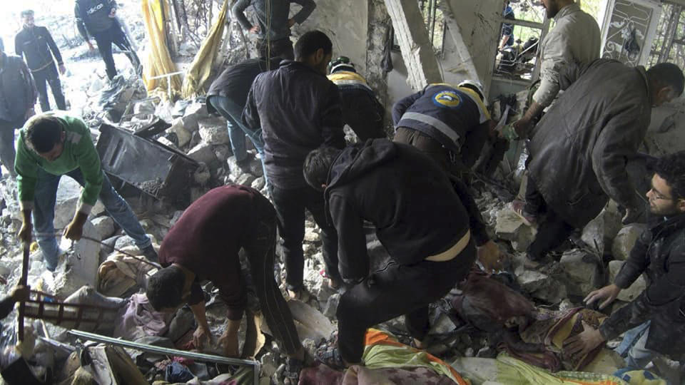 This photo released by the opposition Syrian Civil Defense rescue group, also known as White Helmets, which has been authenticated based on its contents and other AP reporting, shows Civil Defense workers and people searching for victims under the rubble of a destroyed building that was hit by airstrikes in the village of Ibdeita, in Idlib province, Syria, Saturday, Dec. 7, 2019. Airstrikes on areas in the last major rebel stronghold in northwest Syria on Saturday killed at least 18 people, including women and children, and wounded others as a three-month truce crumbles, opposition activists said. (Syrian Civil Defense White Helmets via AP)