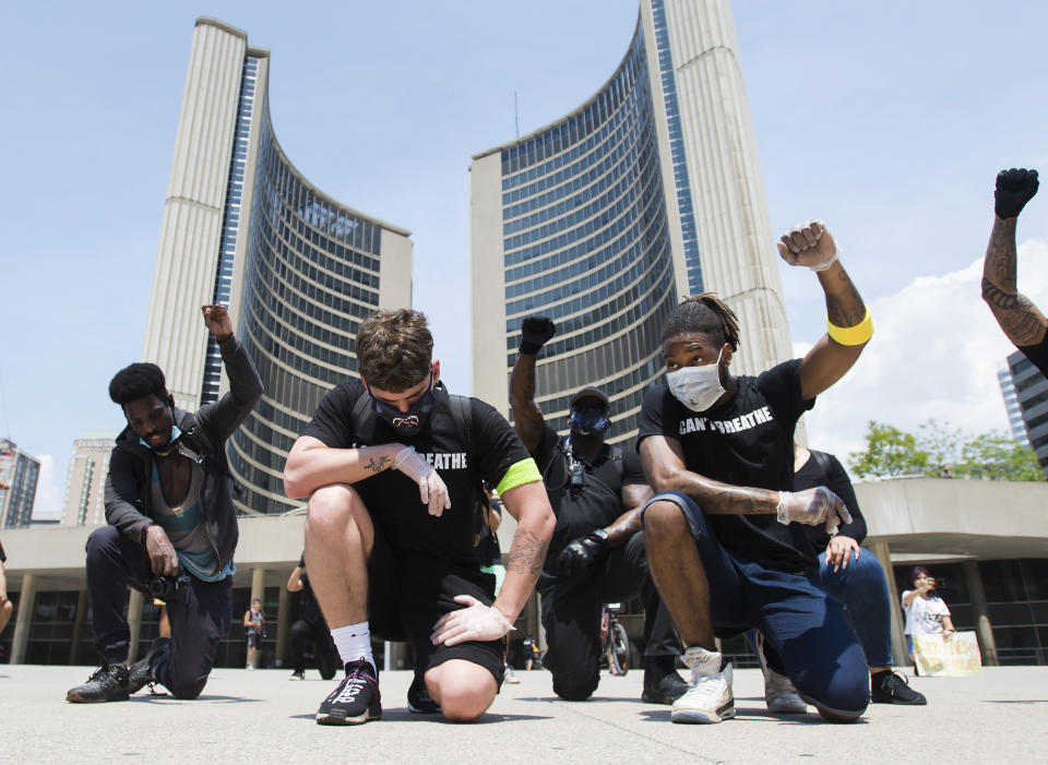 Protesters raise their fists at an anti-racism demonstration, in Toronto on Friday, June 5, 2020. George Floyd, a black man, died after he was restrained by Minneapolis police officers on May 25. His death has ignited protests in the U.S. and worldwide over racial injustice and police brutality. (Nathan Denette/The Canadian Press via AP)