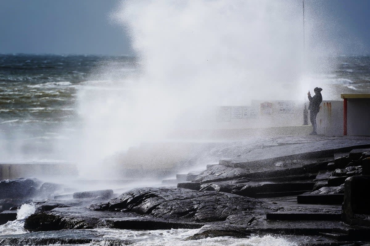 A man takes photos of the waves as Storm Kathleen rages on (Brian Lawless/PA) (PA Wire)