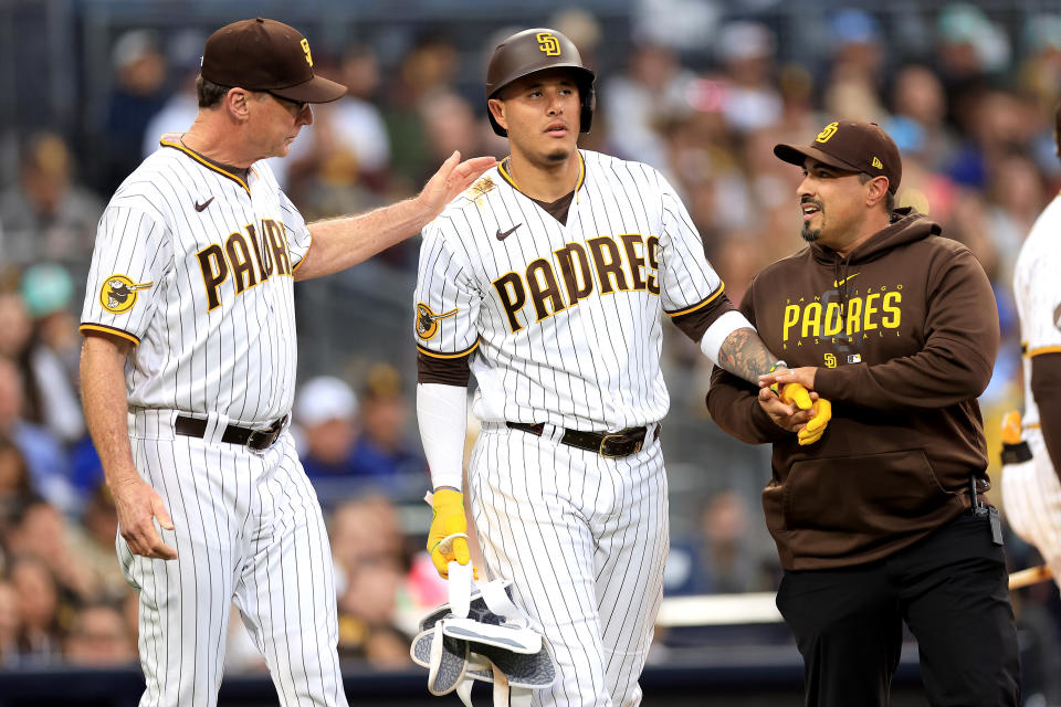 SAN DIEGO, CALIFORNIA - MAY 15: Manager Bob Melvin and trainer Ricky Huerta walk with Manny Machado #13 of the San Diego Padres after he was hit by a pitch on the wrist during the second inning of a game against the Kansas City Royals at PETCO Park on May 15, 2023 in San Diego, California. (Photo by Sean M. Haffey/Getty Images)