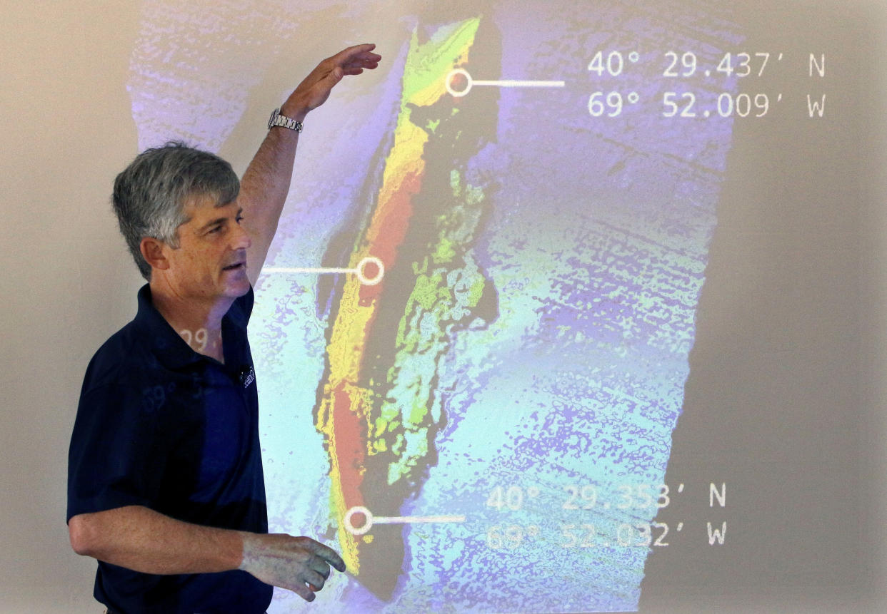 FILE - OceanGate CEO and co-founder Stockton Rush speaks in front of a projected image of the wreckage of the ocean liner SS Andrea Doria during a presentation on their findings after an undersea exploration, on June 13, 2016, in Boston. Rescuers in a remote area of the Atlantic Ocean raced against time Tuesday, June 20, 2023, to find a missing submersible before the oxygen supply runs out for five people, including Stockton, who were on a mission to document the wreckage of the Titanic. (AP Photo/Bill Sikes, File)