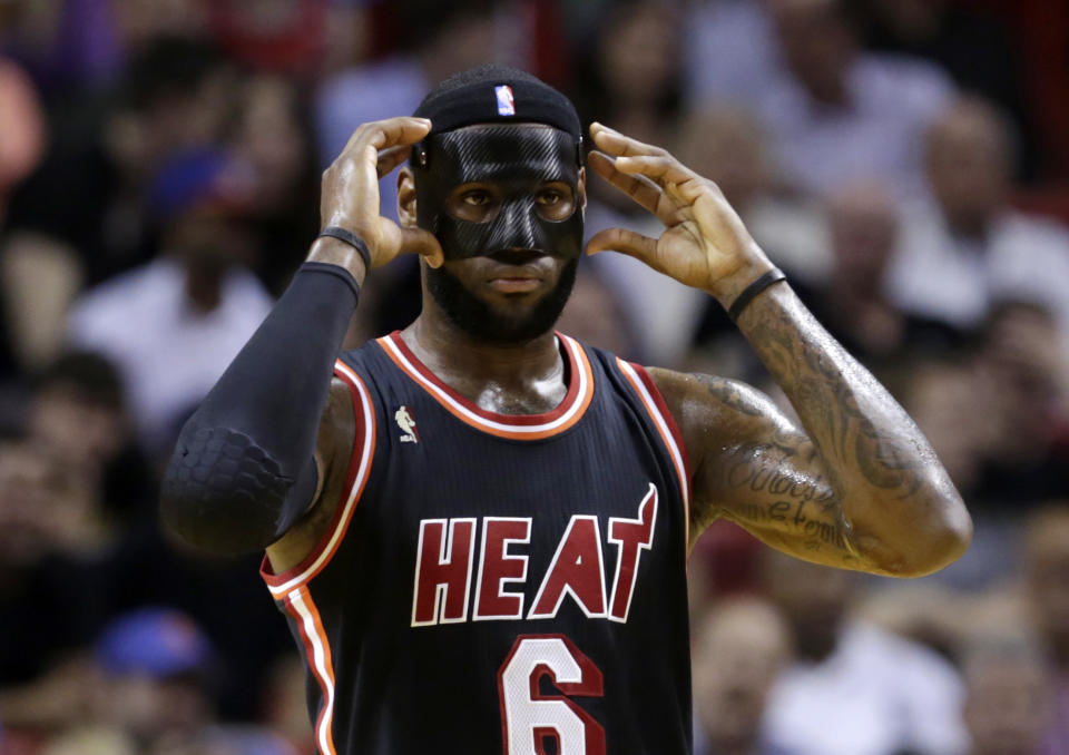 Miami Heat small forward LeBron James (6) adjusts his mask during the first half of an NBA basketball game against the New York Knicks in Miami, Thursday, Feb. 27, 2014. (AP Photo/Alan Diaz)