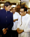India's Shiv Sena party Chief Bal Thackeray (R) speaks to actor Amithab Bachchan (L) while Chairman of Reliance Industry Mukesh Ambani (C) looks on at the inauguration of Thakeray's son Udhav's aerial photographic exibition on the 'Forts of Maharashtra' at the Jahangir Art gallery in Bombay, 19 January 2004. Udhav has a collection of 4000 aerial pictures of 28 forts of the Indian state of Maharashtra of which few have been showcased. 