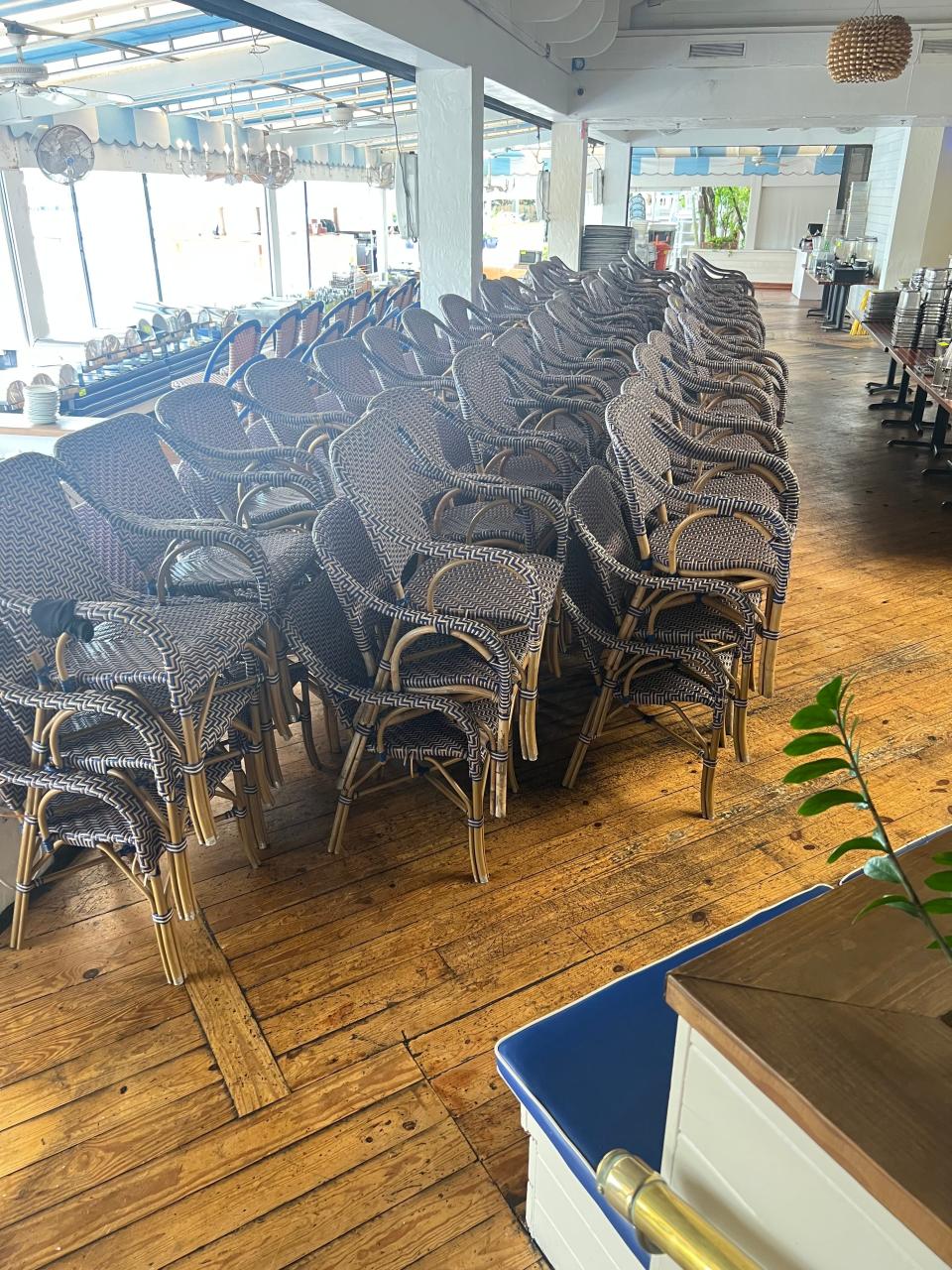Stacks of chairs sit in the Waterway Cafe's sun-filled dining room in preparation for an auction on Saturday, Aug. 26, 2023, at the Palm Beach Gardens restaurant. The chairs and all other equipment and furnishings will be for sale.
