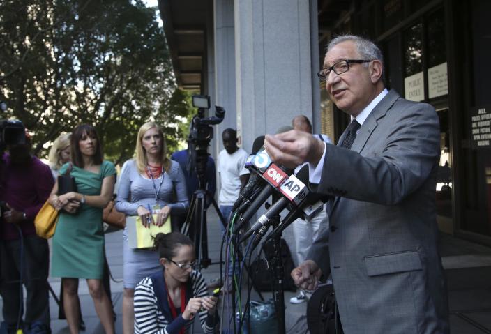 R&B singer Chris Brown's attorney Mark Geragos, right, talks to reporters outside Los Angeles Superior Court on Monday, March 17, 2014. Brown will spend another month in jail after a judge said Monday he was told the singer made troubling comments in rehab about being good at using guns and knives. Brown was arrested on Friday, March 14, 2014, after he was dismissed from a Malibu facility where he was receiving treatment for anger management, substance abuse and issues related to bipolar disorder. (AP Photo/Nick Ut)