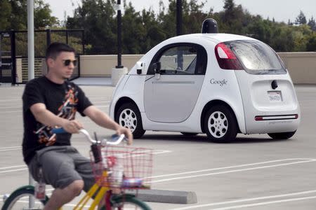 A Google employee on a bicycle acts as a real-life obstacle for a Google self-driving prototype car to react to during a media preview of Google's prototype autonomous vehicles in Mountain View, California September 29, 2015. REUTERS/Elijah Nouvelage