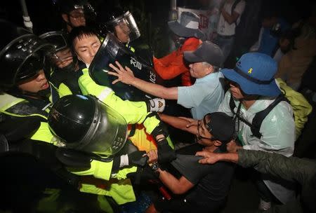 People scuffle with riot policemen during a protest opposing the deployment of a Terminal High Altitude Area Defense (THAAD) system in Seongju, South Korea, September 7, 2017. Lee Sang-hak/Yonhap via REUTERS