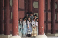 Visitors wearing traditional "Hanbok" outfits take a selfie in the snow at the Gyeongbok Palace, the main royal palace during the Joseon Dynasty, and one of South Korea's well known landmarks in Seoul, South Korea, Thursday, Jan. 26, 2023. (AP Photo/Ahn Young-joon)