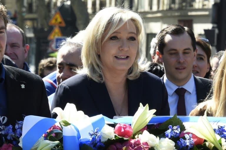 Leader of the French far-right party Front National, Marine Le Pen, lays flowers at a statue of Joan of Arc in Paris on May 1, 2016