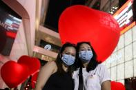 Women wearing protective poses in front of hearts celebrating Valentine's Day in front of shopping mall in Bangkok