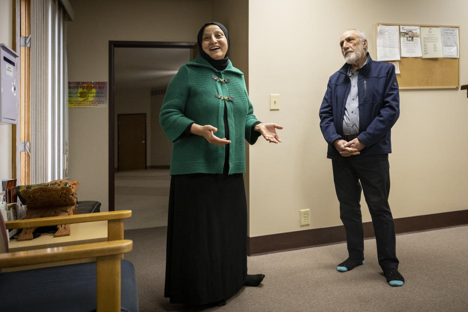 Bibi Bahrami and her husband, Dr. Mohammad Saber Bahrami, stand together at the Islamic Center of Muncie, Ind., on Friday, March 3, 2023, where she is one of the mosque's leaders. She is a subject of the documentary "Stranger at the Gate" that tells the story of the relationship she and others in their small Islamic community fostered with Richard McKinney, a former U.S. Marine who at one point had planned to bomb their community center. (AP Photo/Doug McSchooler)