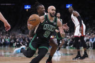 Boston Celtics guard Derrick White (9) drives to the basket past Miami Heat guard Delon Wright, center rear, during the first half of Game 5 of an NBA basketball first-round playoff series, Wednesday, May 1, 2024, in Boston. (AP Photo/Charles Krupa)