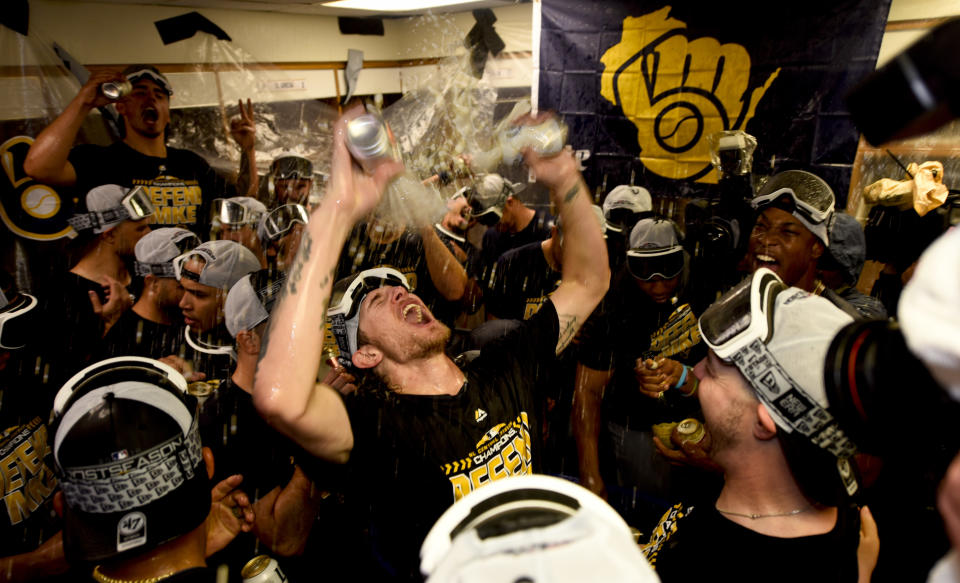 Milwaukee Brewers relief pitcher Josh Hader, center, and other players celebrate in the club house after defeating the Chicago Cubs 3-1 in a tiebreak baseball game on Monday, Oct. 1, 2018, in Chicago. (AP Photo/Matt Marton)