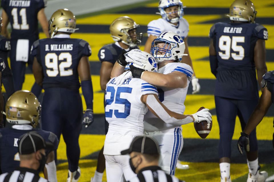 BYU running back Tyler Allgeier (25) celebrates with offensive lineman Clark Barrington (56) after scoring a touchdown during the second half of an NCAA college football game against Navy, Monday, Sept. 7, 2020, in Annapolis, Md. (AP Photo/Tommy Gilligan)