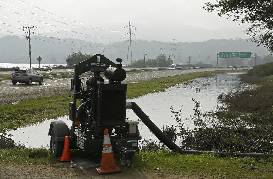 In this Tuesday, Jan. 17, 2017, photo a pump removes water from a flooded are along Highway 37 near Novato, Calif. Flooding and high surf in California are giving residents a preview of what sea rise is going to be like for the Pacific Coast state. Ecologist Fraser Shilling at the University of California, Davis says more damaging storms are the new normal with sea rise. (AP Photo/Eric Risberg)
