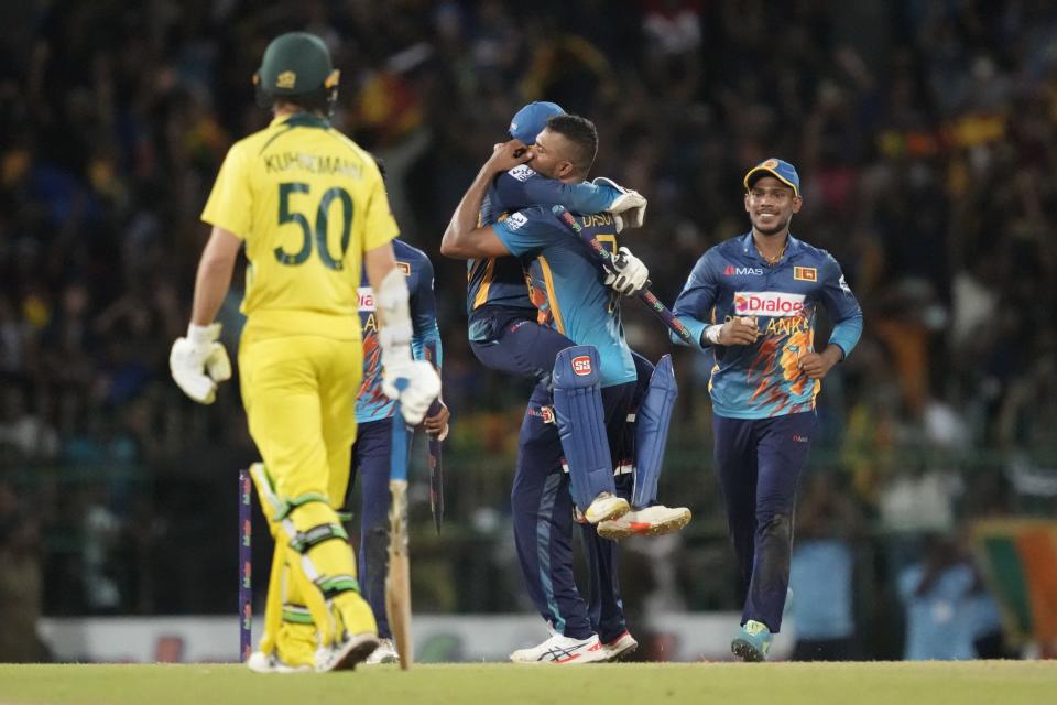 Sri Lanka's captain Dasun Shanaka is hugged by his teammates as they celebrate their team's victory over Australia by four runs in the fourth one-day international cricket mach between Australia and Sri Lanka in Colombo, Sri Lanka, Tuesday, June 21, 2022. (AP Photo/Eranga Jayawardena)