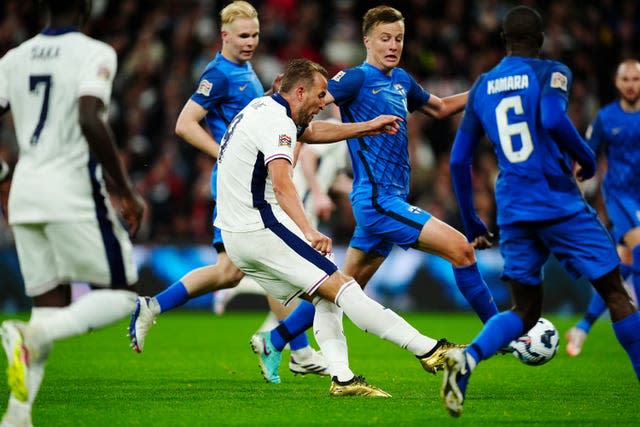 Harry Kane, wearing gold boots and surrounded by Finland defenders, scores his first of two goals on his 100th England appearance