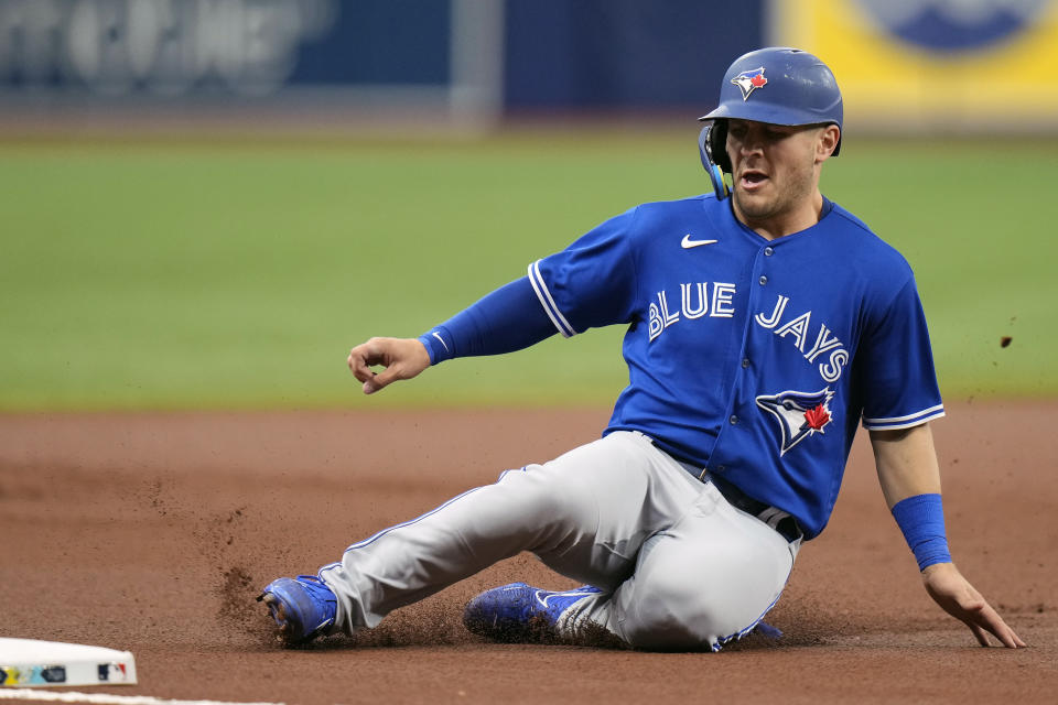 Toronto Blue Jays' Daulton Varsho slides into third base ahead of the throw to Tampa Bay Rays' Taylor Walls on a single by Vladimir Guerrero Jr. during the first inning of a baseball game Thursday, May 25, 2023, in St. Petersburg, Fla. (AP Photo/Chris O'Meara)