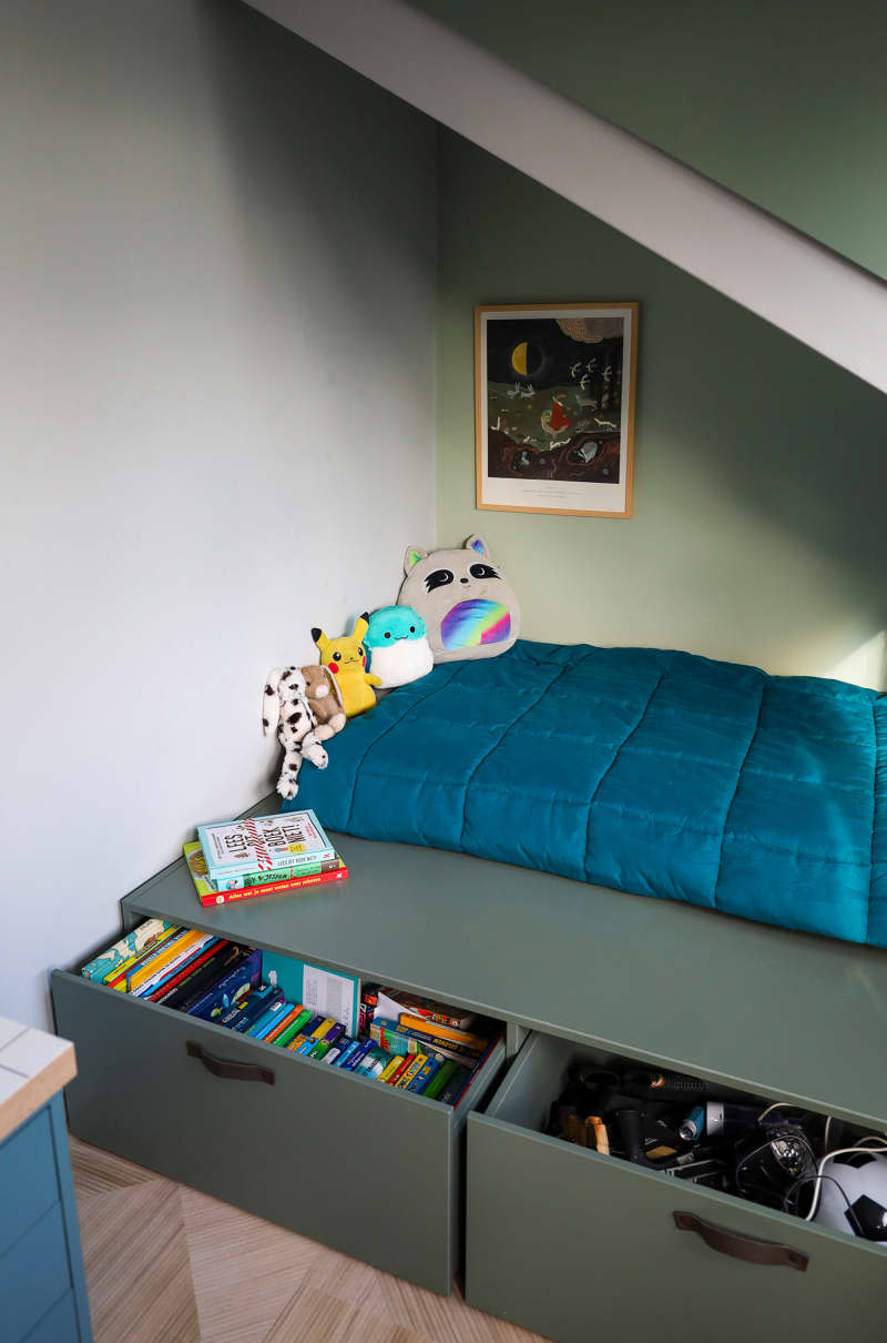 Drawers open on storage bed topped with stuffed animals.