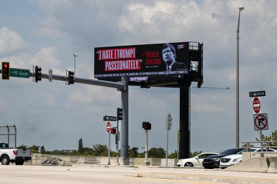 A billboard on April 3, 2023, near former President Donald Trump's Mar-a-Lago estate in Palm Beach, Fla., quotes Tucker Carlson's private text message, made public in court filings: "I hate [Trump] passionately."