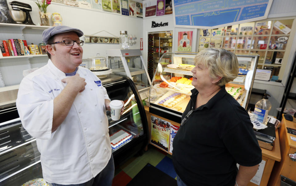 Mitchell Moore, a baker, left, talks with Tina Fortenberry, in his Jackson, Miss., store Tuesday, April 22, 2014. Moore and some other business owners wanted to show support for gay and lesbian customers by pushing back against a religious-practices bill signed earlier this year by Republican Gov. Phil Bryant, by distributing and displaying round, blue window stickers that declare: “We don’t discriminate. If you’re buying, we’re selling." (AP Photo/Rogelio V. Solis)
