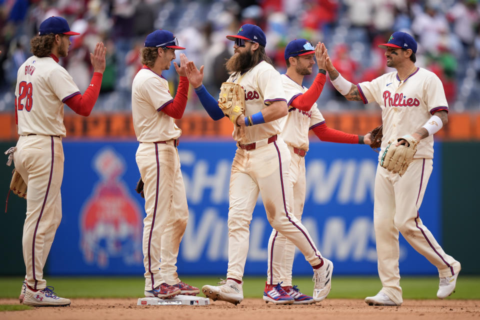 Philadelphia Phillies' Alec Bohm, from left, Bryson Stott, Brandon Marsh, Trea Turner and Nick Castellanos celebrate after winning a baseball game against the Chicago White Sox, Sunday, April 21, 2024, in Philadelphia. (AP Photo/Matt Slocum)