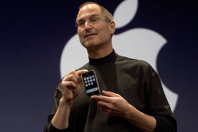 <p>David Paul Morris/Getty</p> Steve Jobs holds up an iPhone in 2007