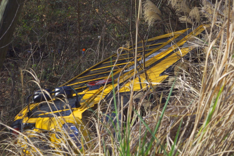 This photo provided by WYMT-TV shows a school bus after crashing over an embankment near near Salyersville, Ky., on Monday, Nov. 14, 2022. The driver and 18 children were sent to hospitals with injuries ranging from minor to severe, authorities said. (WYMT-TV via AP)