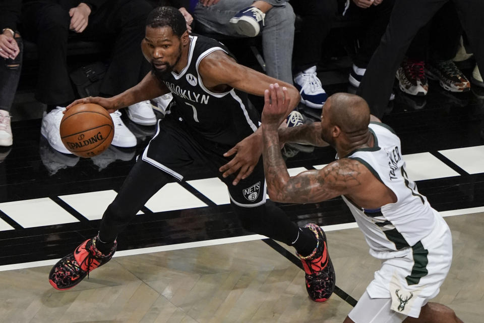 Brooklyn Nets' Kevin Durant, left, drives past Milwaukee Bucks' P.J. Tucker during the first half of Game 7 of a second-round NBA basketball playoff series Saturday, June 19, 2021, in New York. (AP Photo/Frank Franklin II)