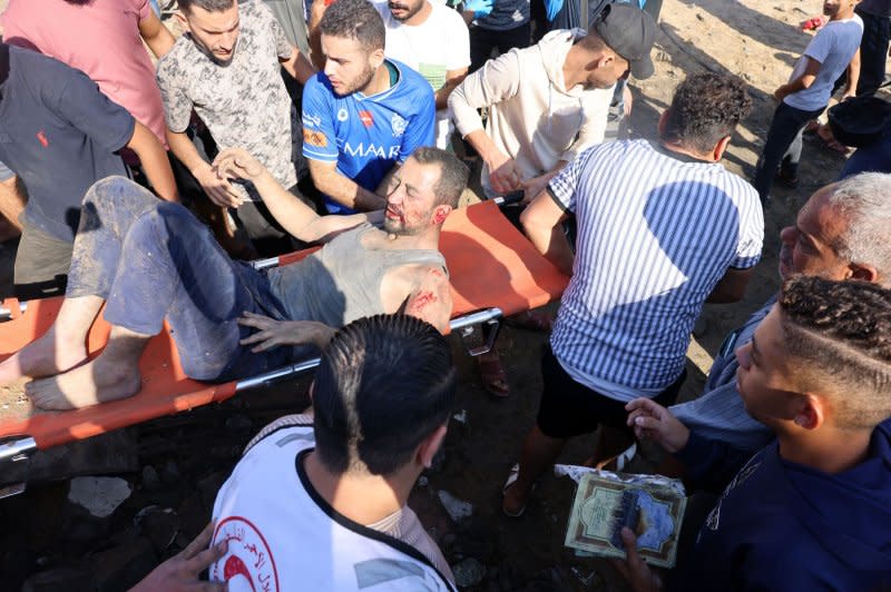 Emergency responders and residents carry a wounded Palestinian man on a stretcher after Israeli airstrikes in Rafah in the Gaza Strip on Friday. Photo by Ismael Mohamad/UPI