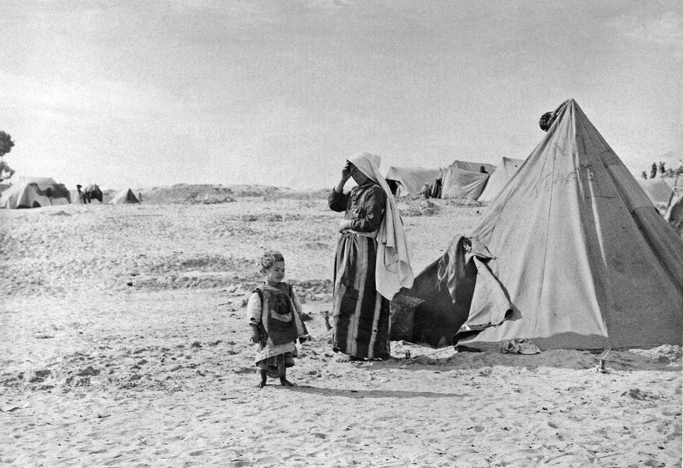 In this 1948 photo from the U.N. Relief and Works Agency, UNRWA, archive, Palestinian refugees stand outside their tent in Khan Younis, Gaza Strip. The photo is part of UNWRA's vast photo archive being digitized in Gaza and Denmark to preserve a record of one of the world's most entrenched refugee problems, created in what the Palestinians call the "Nakba," or “catastrophe”-- their uprooting in the war over Israel's 1948 creation. (AP Photo/UNRWA Photo Archives)