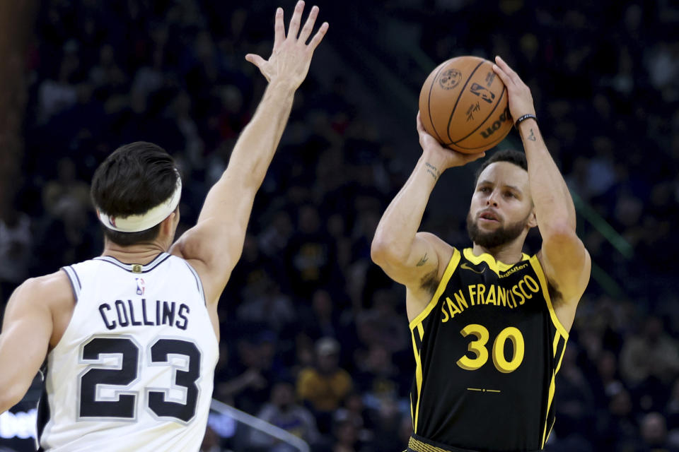 Golden State Warriors guard Stephen Curry (30) looks to shoot against San Antonio Spurs forward Zach Collins (23) during the first half of an NBA basketball In-Season Tournament game in San Francisco, Friday, Nov. 24, 2023. (AP Photo/Jed Jacobsohn)